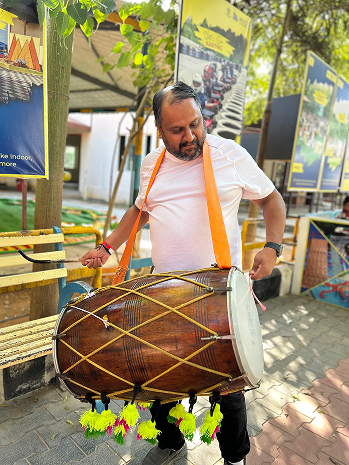 Employees performing traditional drum activity during cultural event